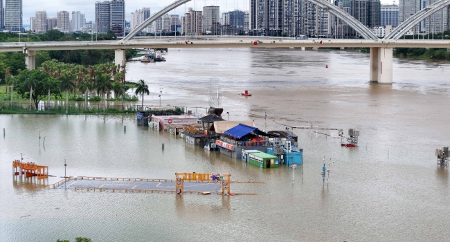 Flooded shops along a submerged riverside walk are seen by the overflowing Yongjiang River in Nanning, in China’s southern Guangxi region, on July 7, 2026. Photo by – / CN-STR / AFP